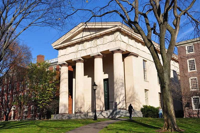 A columned building is featured beyond a well-kept lawn at Brown University.