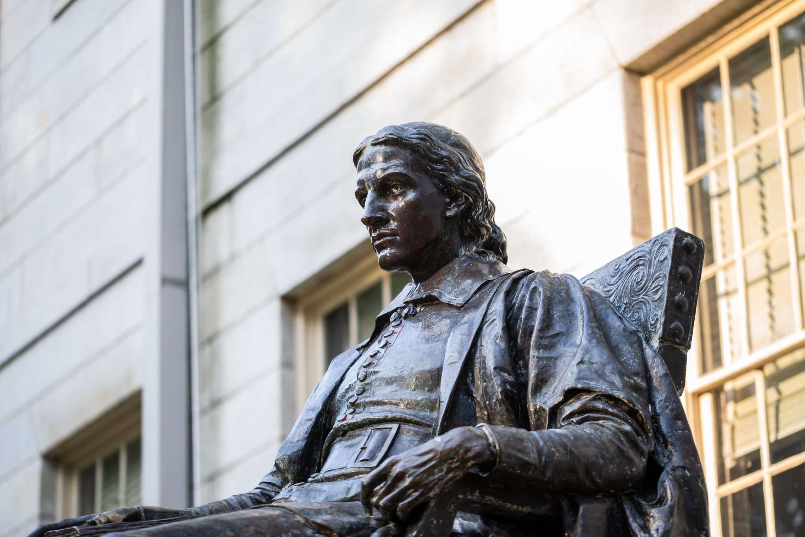 A bronze statue of John Harvard is featured at Harvard University.
