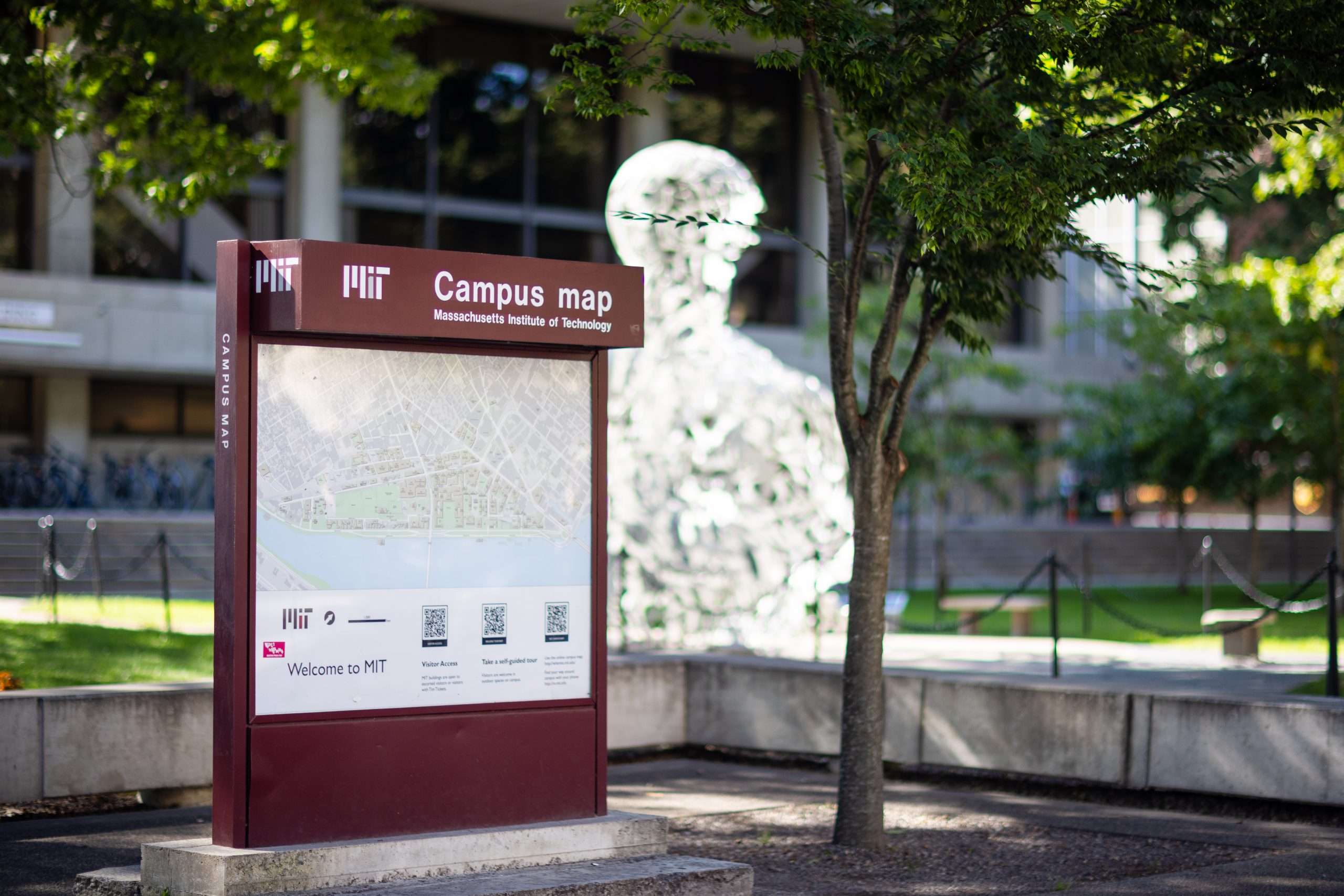 An MIT campus map is featured next to a statue.