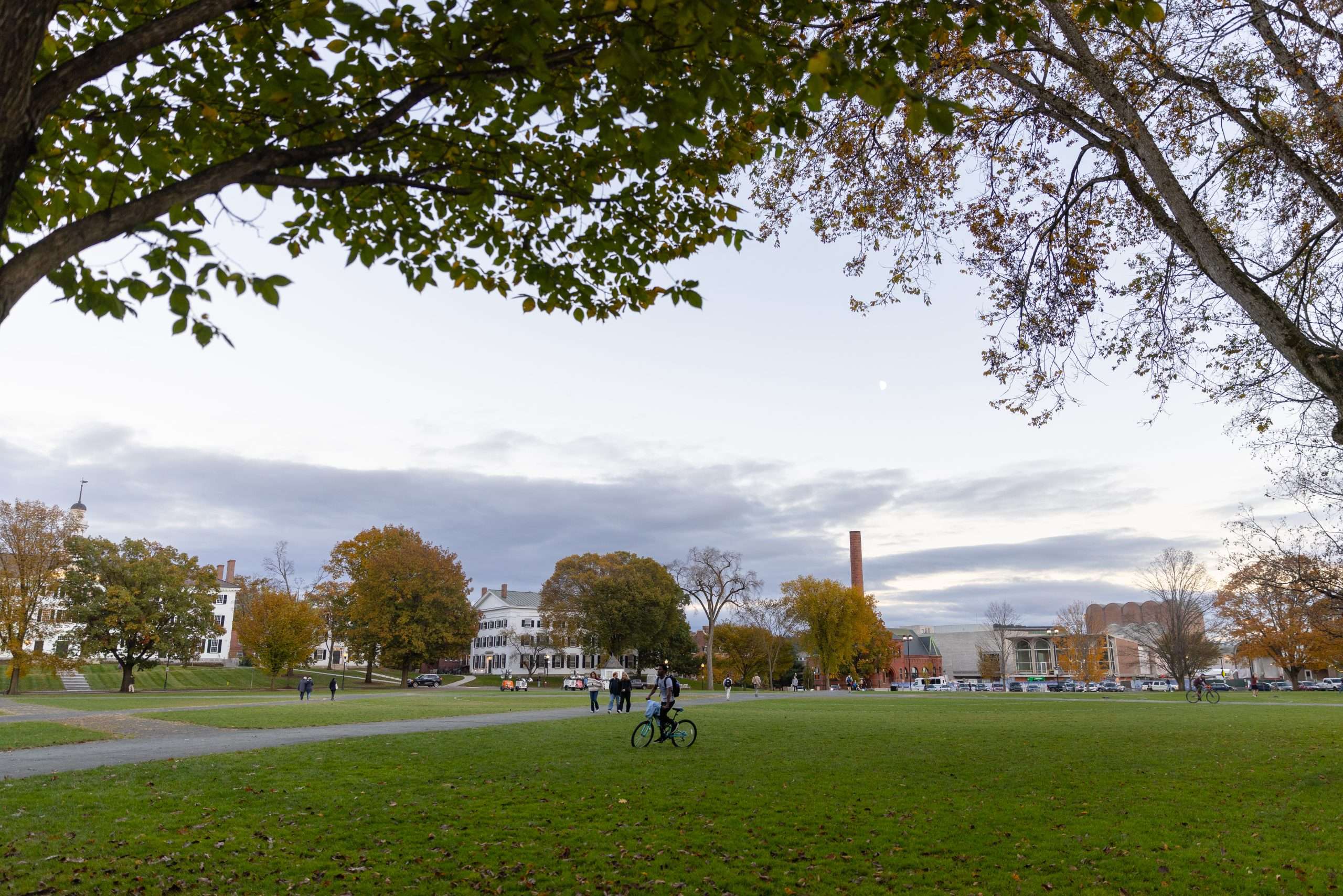 A student bikes across the Green at Dartmouth College.