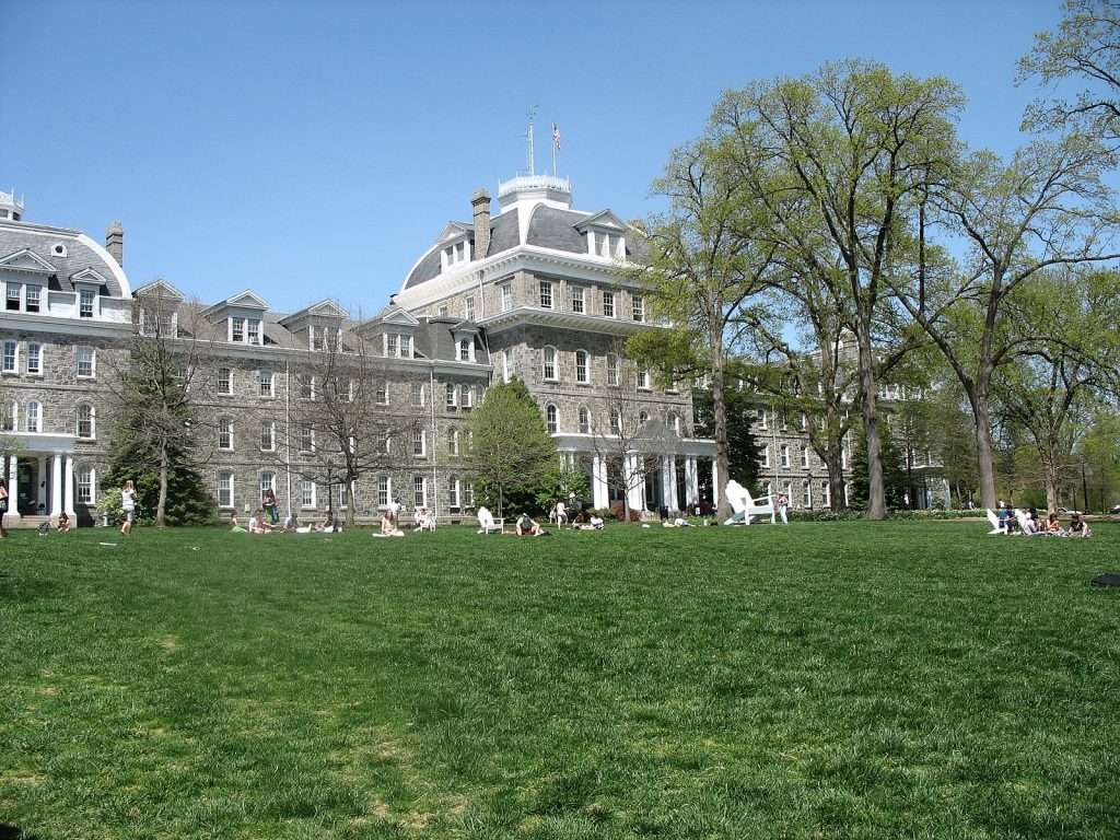 Parrish Hall is featured beyond students lounging on the lawn at Swarthmore College.