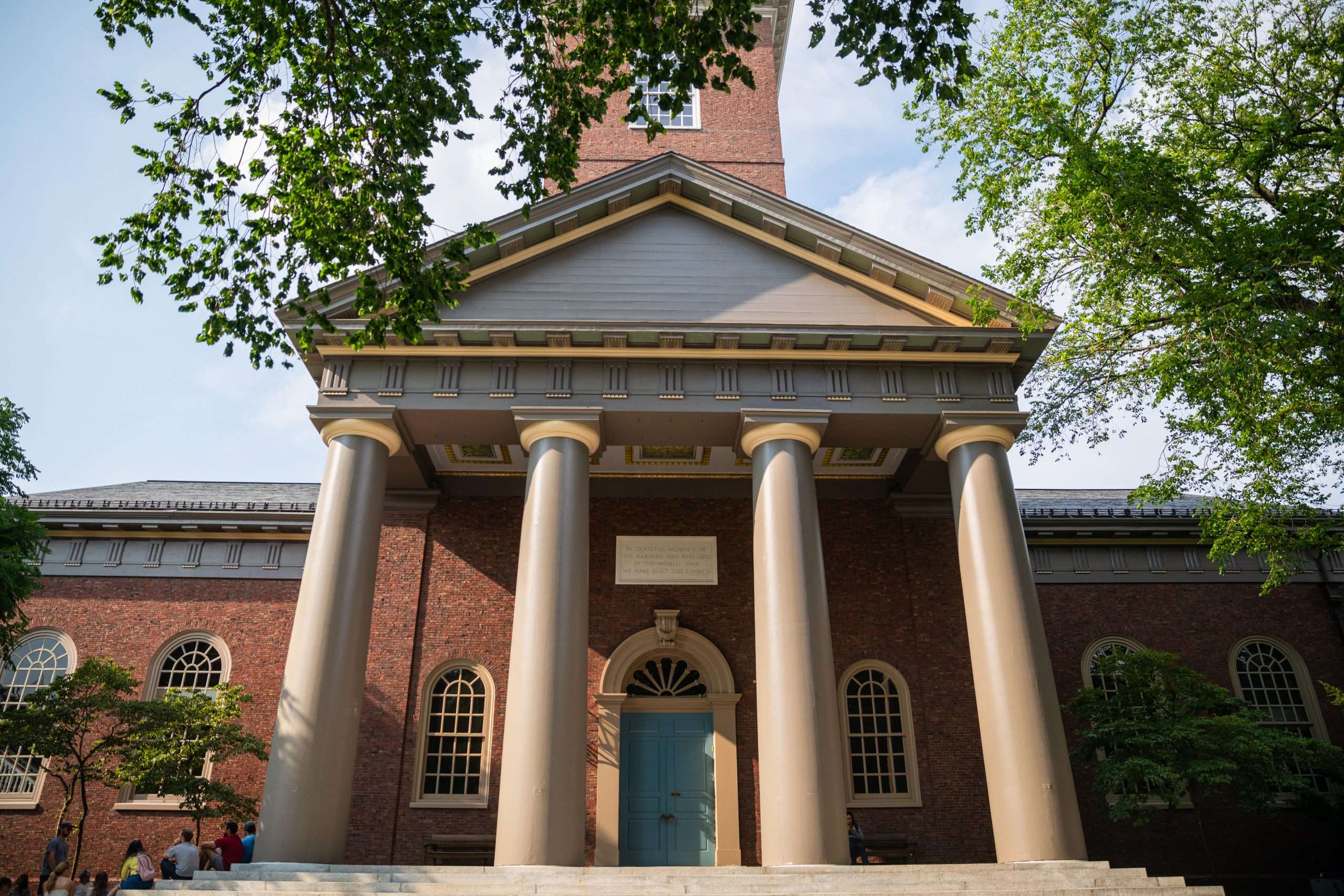 A columned building with a blue door is featured at Harvard University.